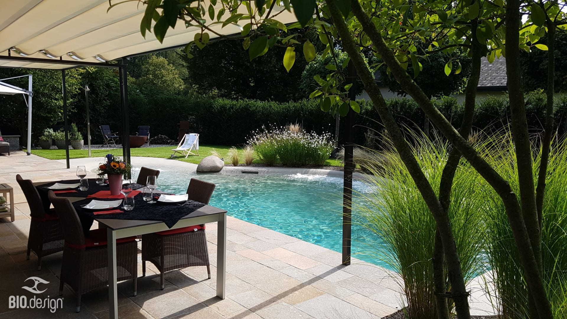 Bio.design Pool – Blick von der Terrasse mit Esstisch