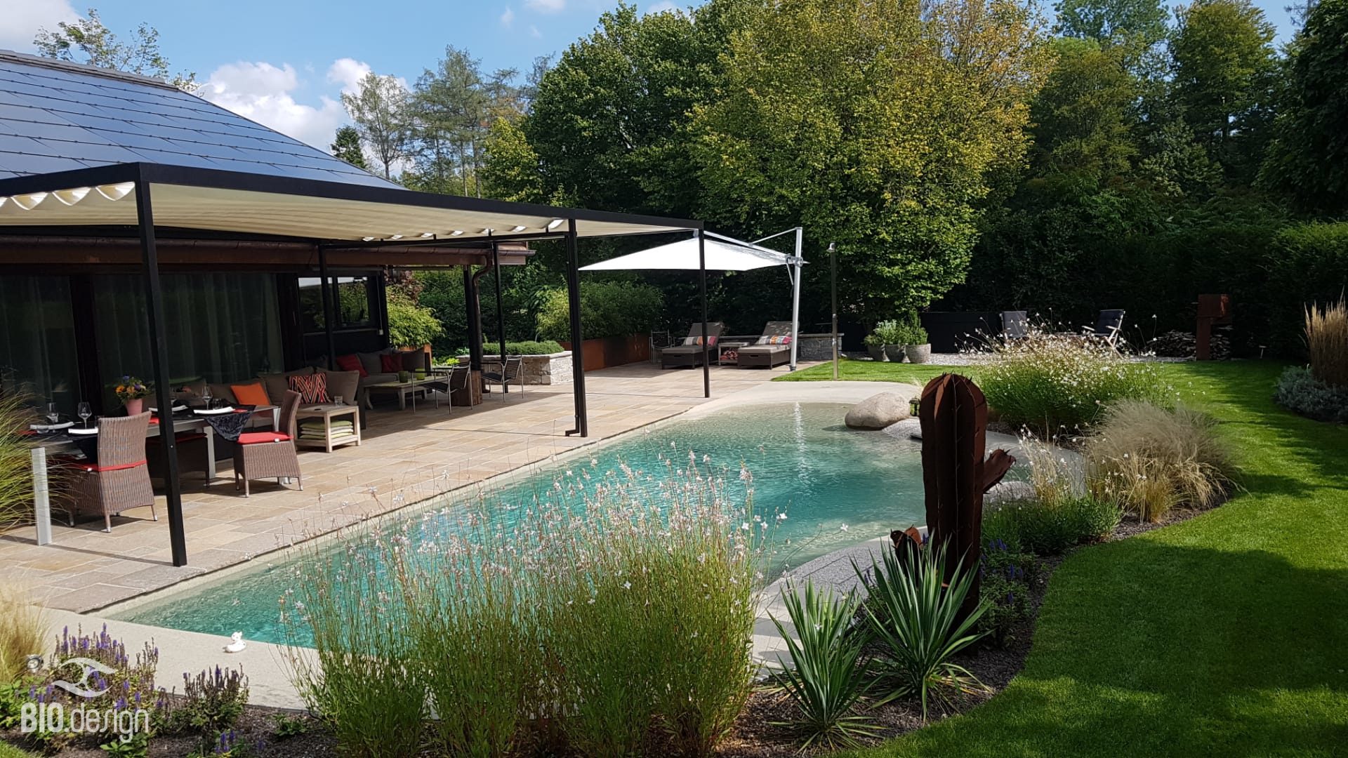 Bio.design Pool – Gesamtansicht mit Terrasse und Garten